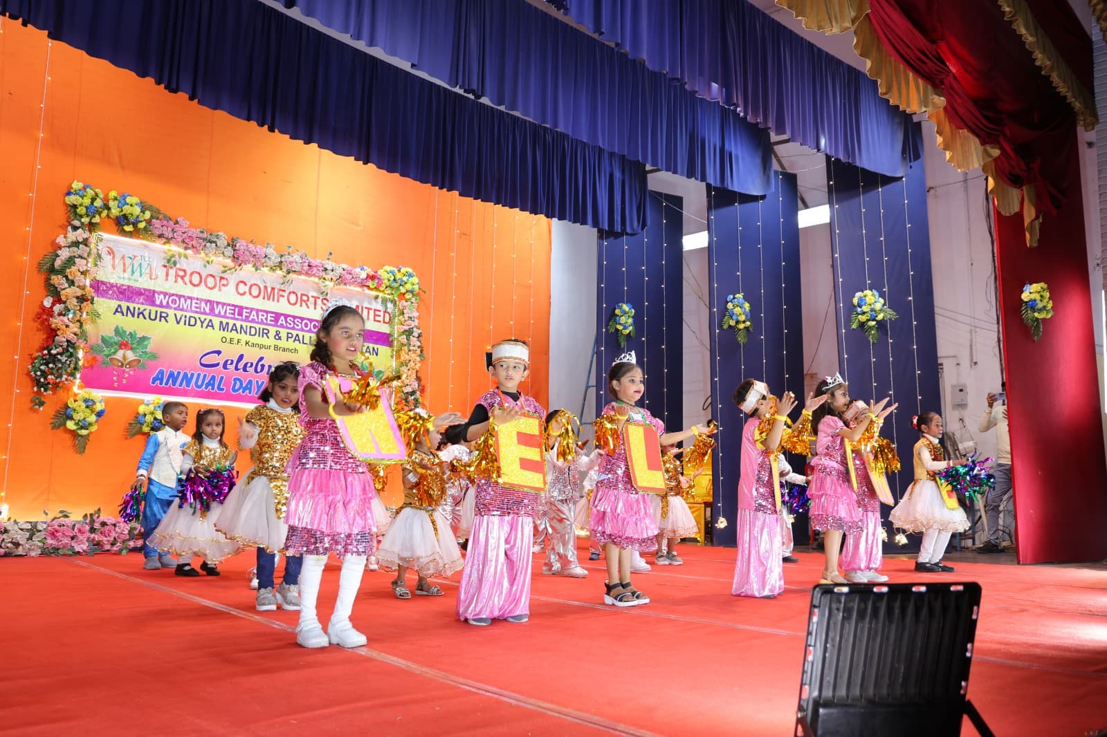 Pre-primary children dancing with letter signs on stage